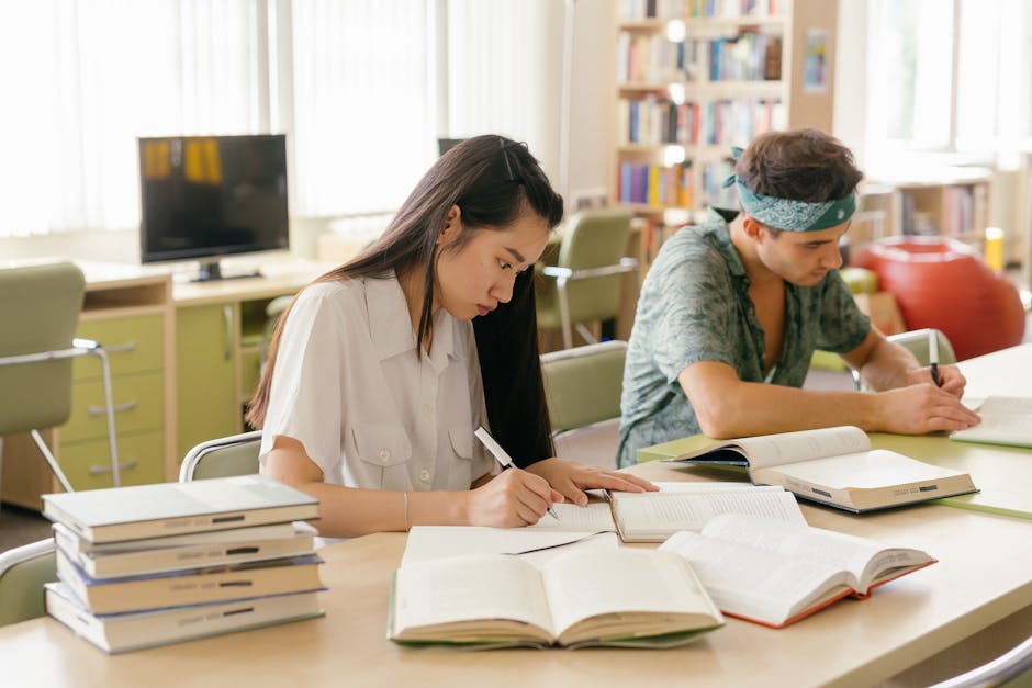 College students studying and taking notes in a library setting
