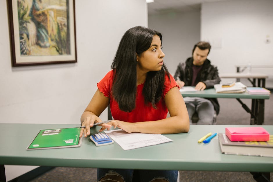 Students taking a test in a classroom, with one woman looking sideways